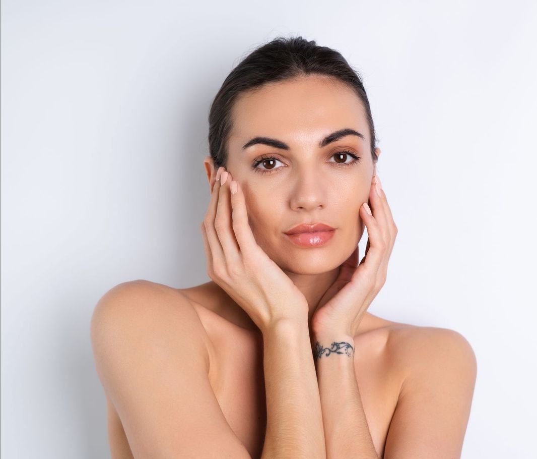 A woman looking at her wrinkles in front of camera.