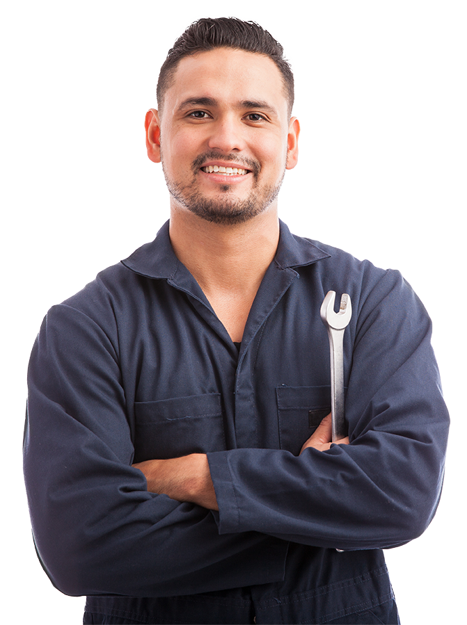 A man in a blue jumpsuit is holding a wrench and smiling.