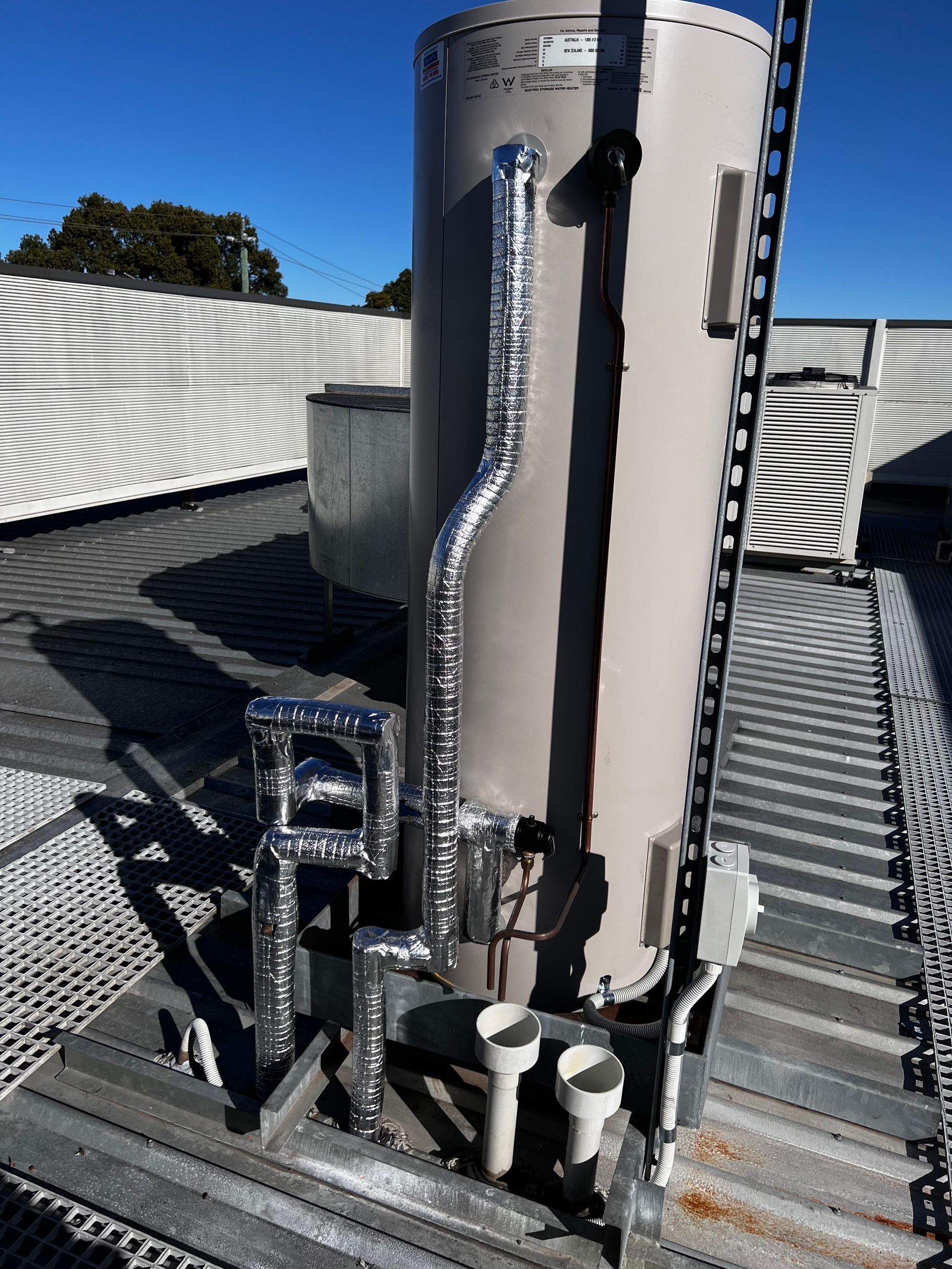 A large water heater is on the roof of a building