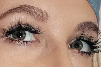 A close up of a woman 's eyes with long eyelashes.