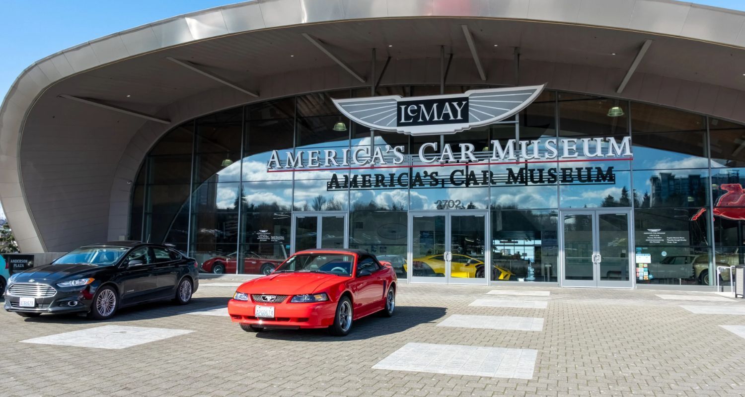 America's Car Museum entrance with a red car and a black car parked in front.