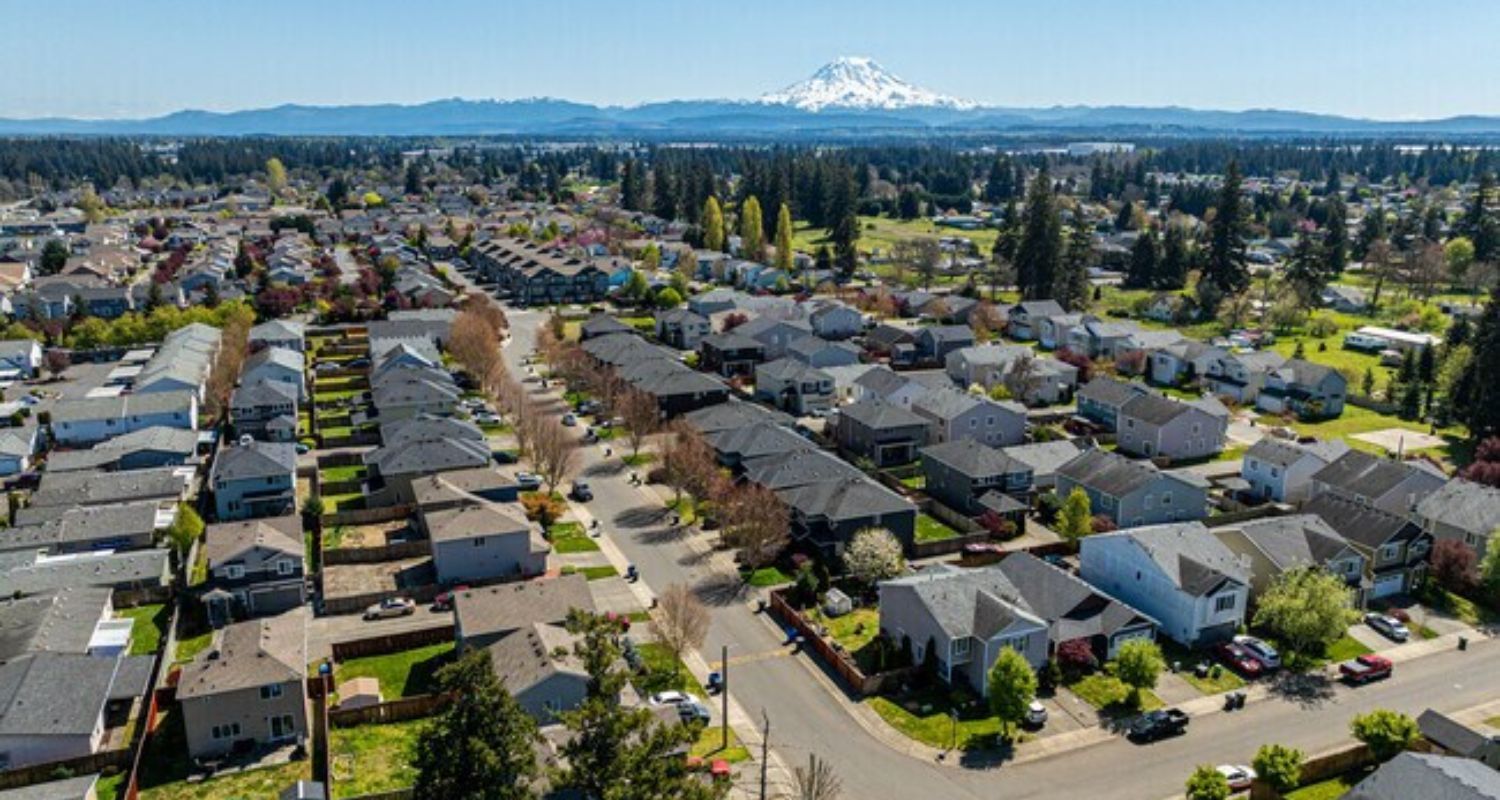 Residential neighborhood with view of snow-capped mountain under a blue sky.