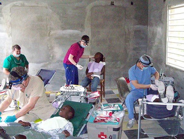A group of dentists are working on a child 's teeth