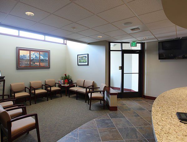 A waiting room with a green exit sign on the door