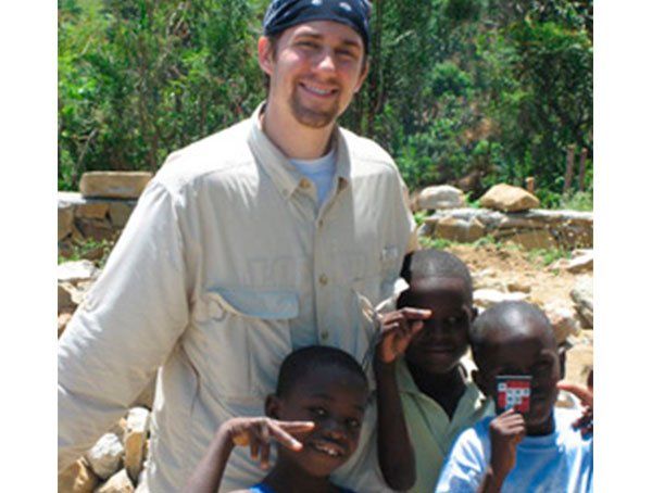 A man is posing for a picture with two young boys