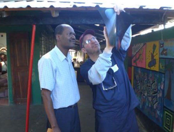 A man in a blue shirt is standing next to another man