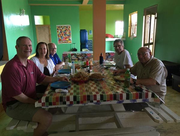 A group of people are sitting around a table with food on it
