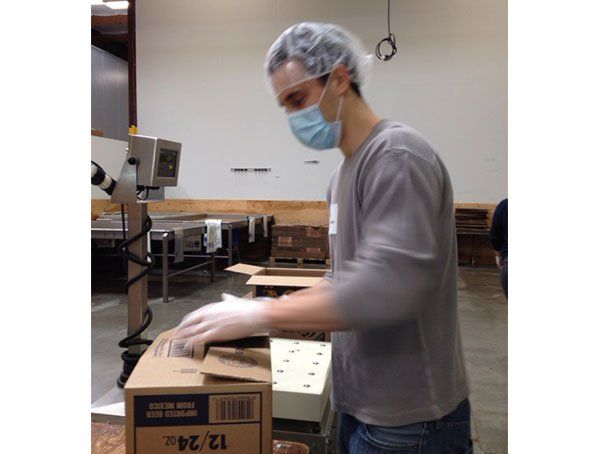 A man wearing a mask is working in a factory