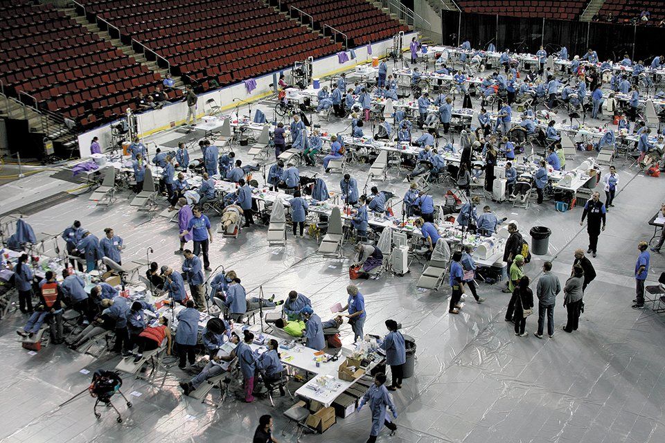 A large group of people are sitting at tables in a stadium