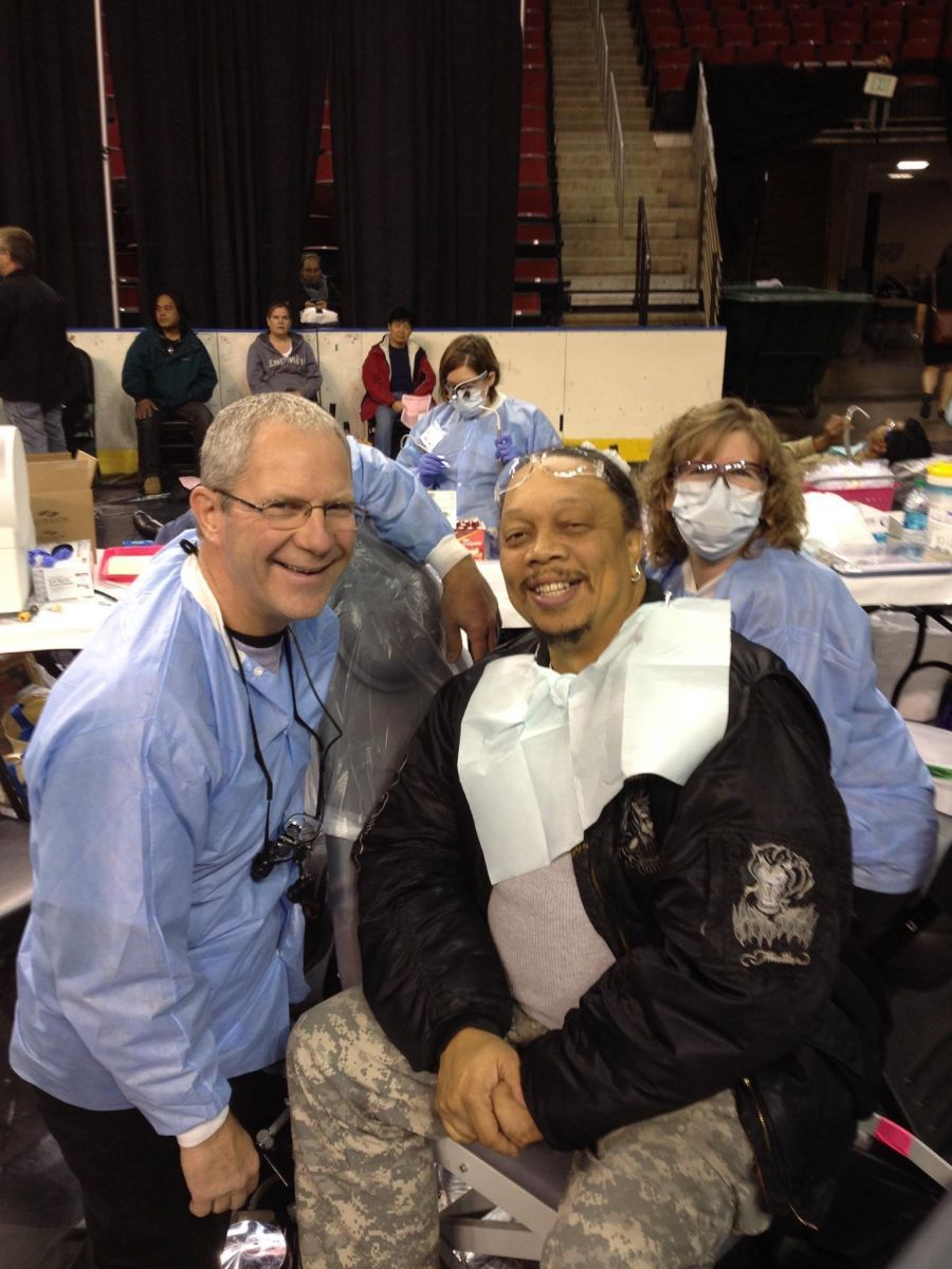 A man in a military uniform is sitting in front of a group of people