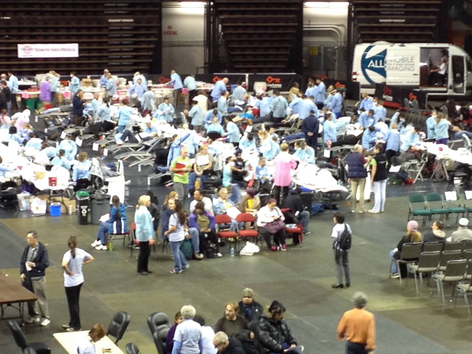 A large group of people are gathered in a room with a sign that says all