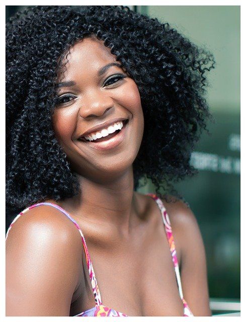 A woman with curly hair is smiling for the camera