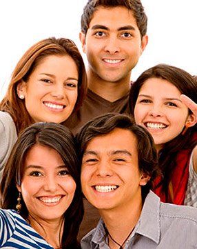 A group of young people are posing for a picture and smiling for the camera.