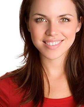 A woman in a red shirt is smiling for the camera.