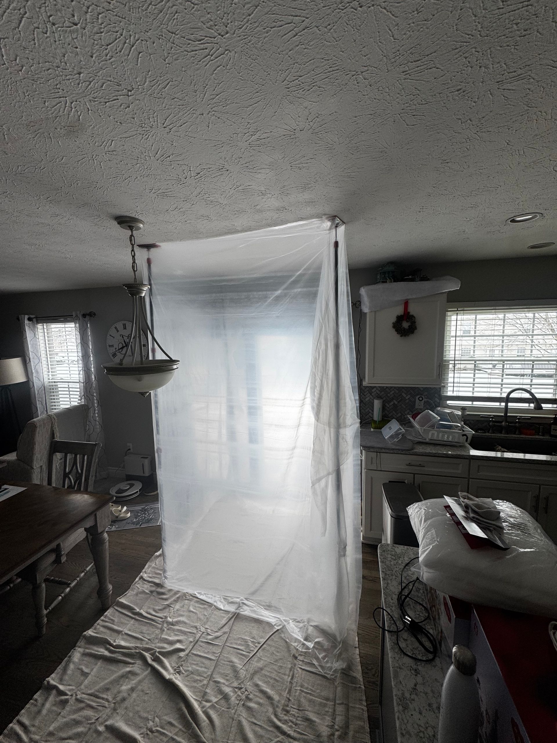 Clear plastic sheeting creates a barrier in a room, protecting from paint or dust.