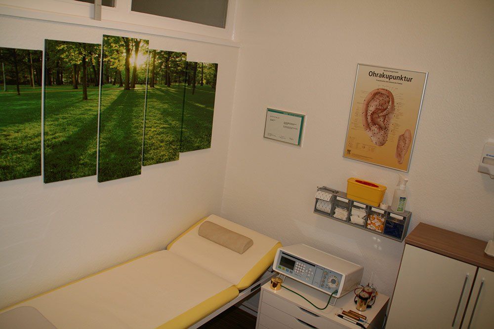 Eine Arztpraxis mit einem Bett und einem Gemälde an der Wand.