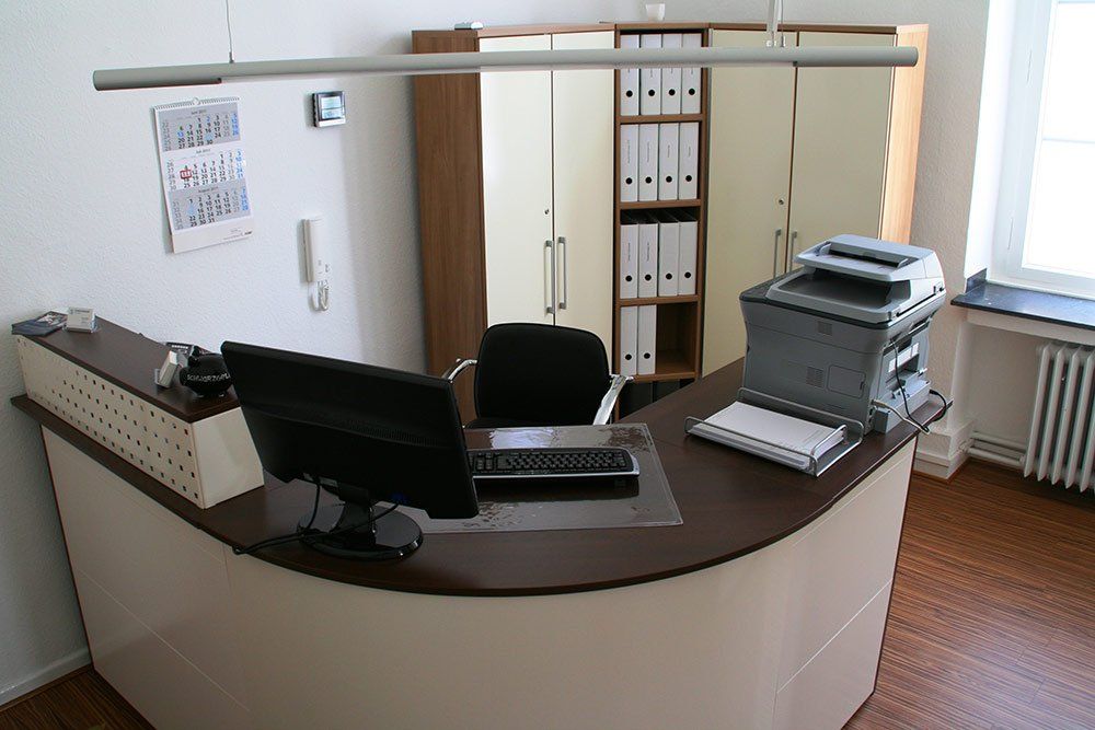 Ein Schreibtisch mit einem Computer und einem Drucker darauf