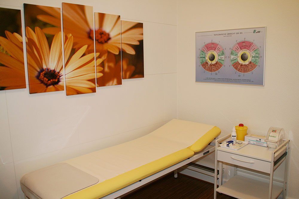 Ein Zimmer mit einem Bett und einem Blumengemälde an der Wand