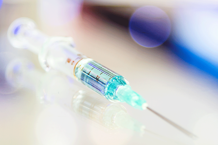 Eine Nahaufnahme einer Spritze mit einer Nadel auf einem Tisch.