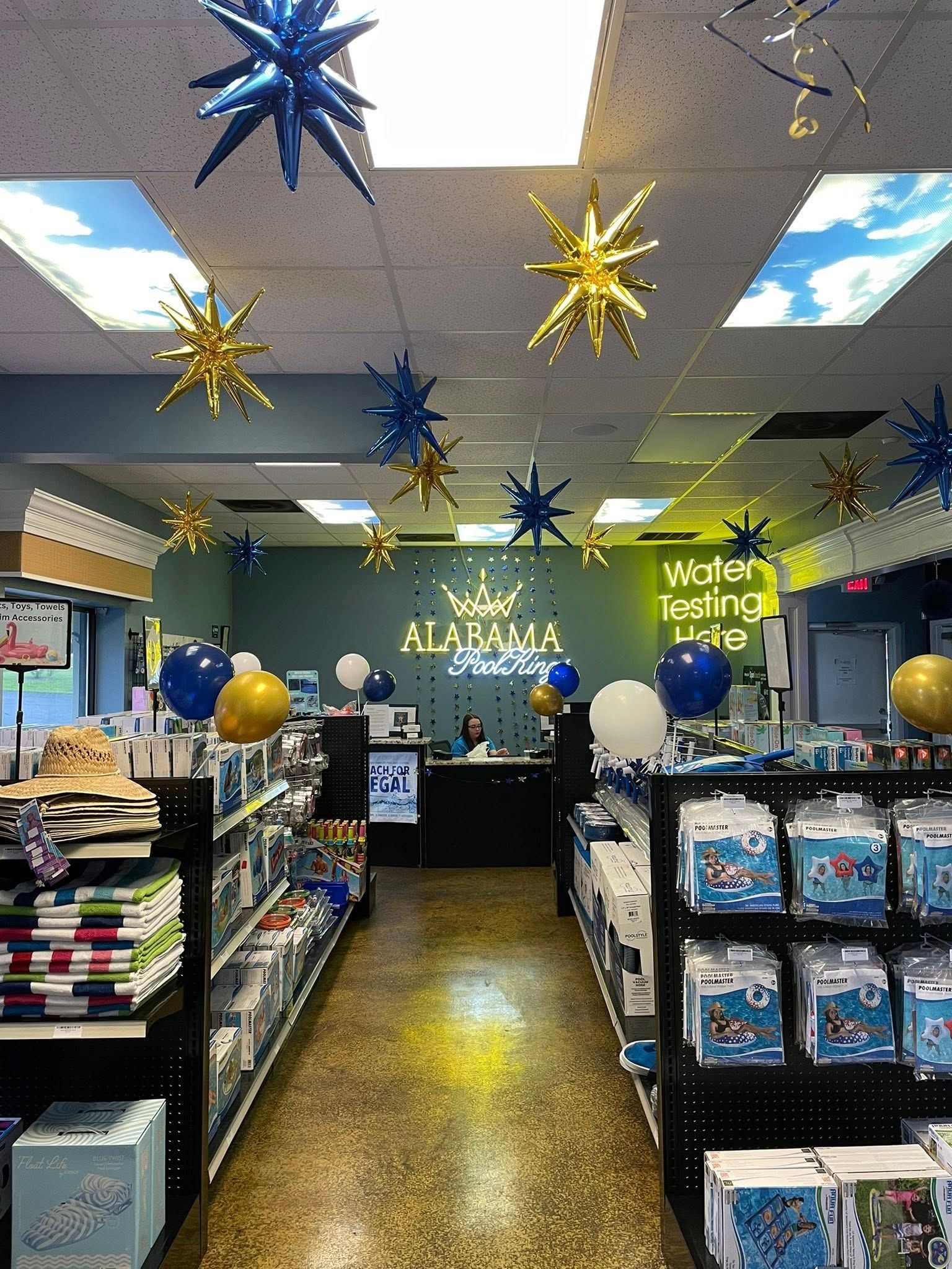 Decorated classroom store aisle with hanging blue and gold star ornaments and shelves of supplies