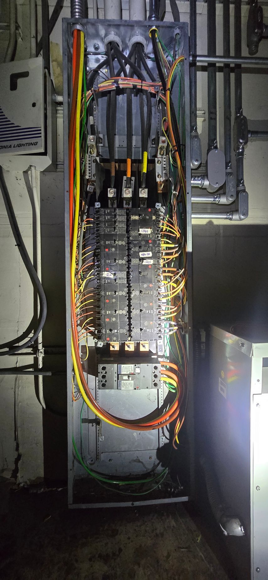 Open electrical control cabinet with wiring, circuit boards, and cables inside a metal enclosure.