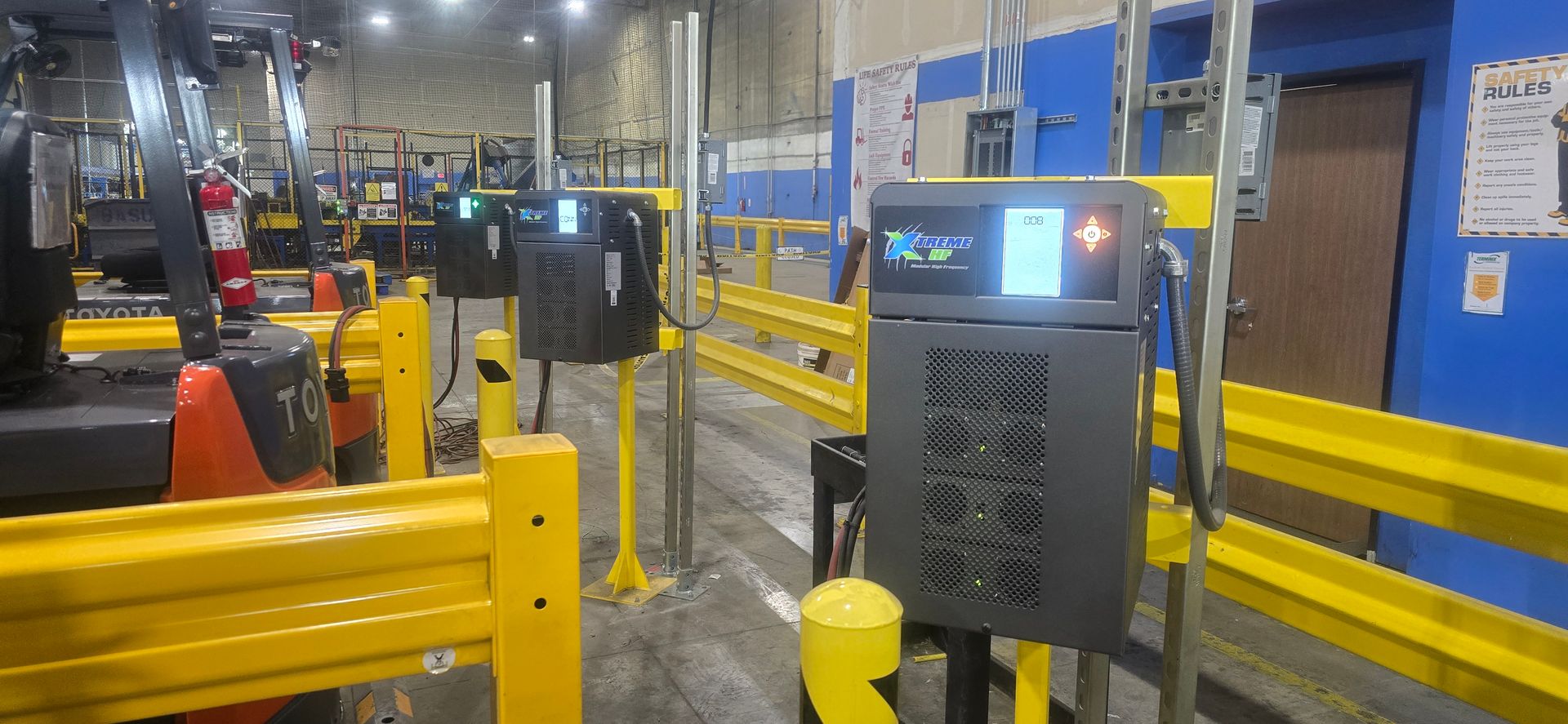 Industrial facility with yellow safety rails and a control kiosk in the foreground