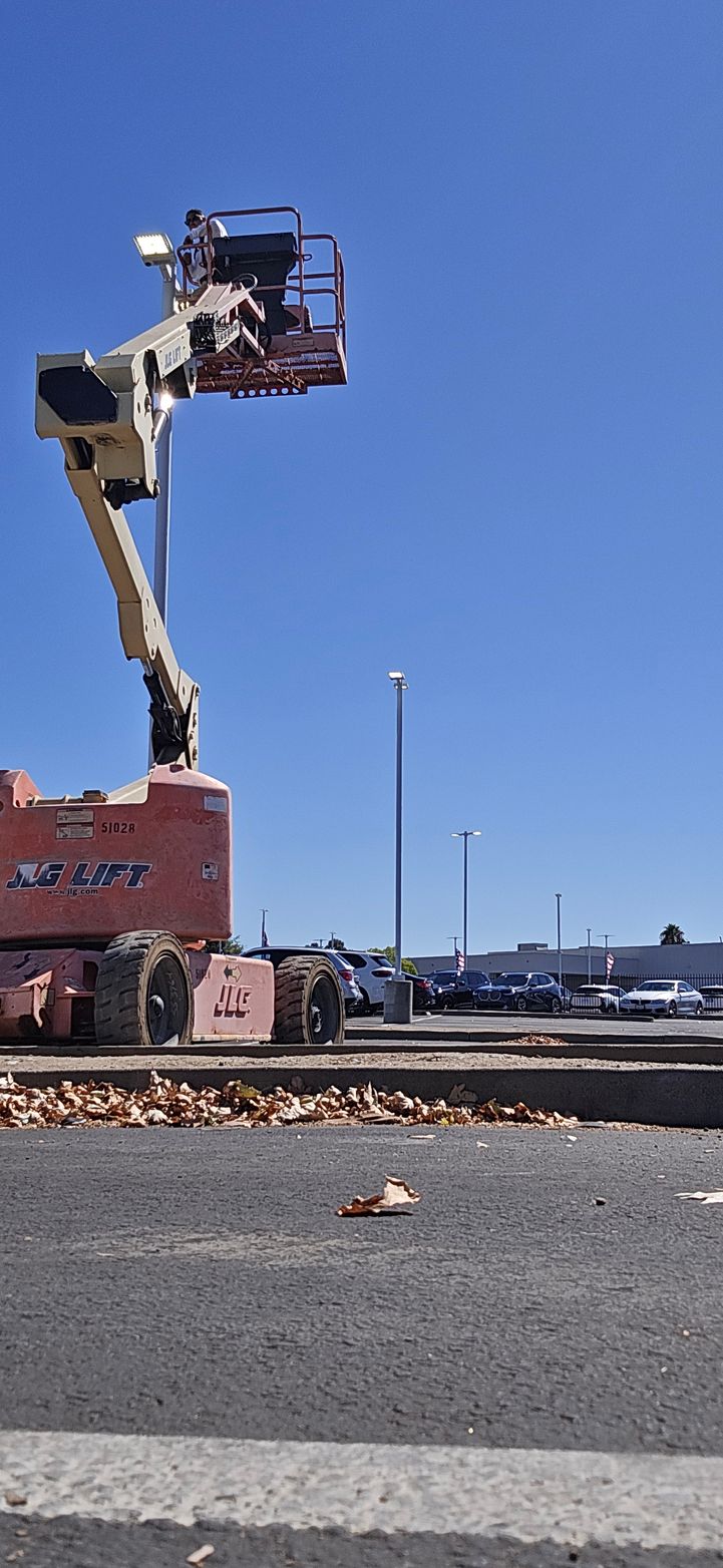 Fire truck ladder raised above a parking lot on a clear blue day