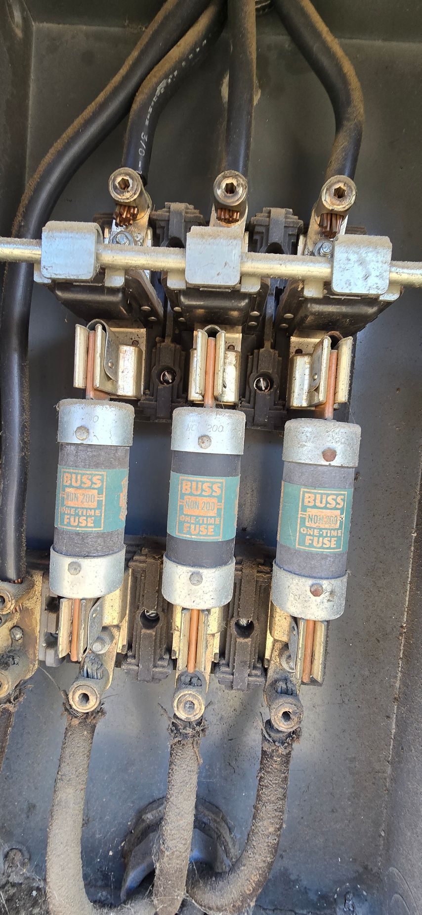 Three electrical fuse holders with wires inside a panel, slightly worn and dusty.