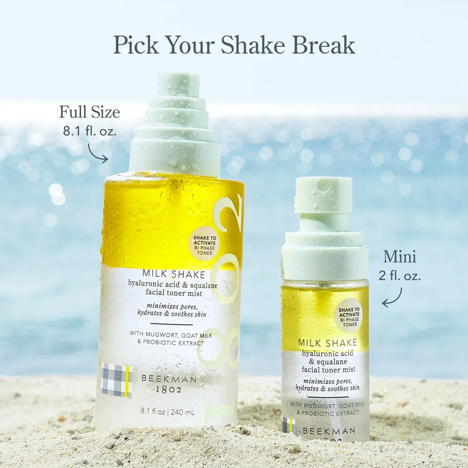 Two bottles of milk shake are sitting on a sandy beach.