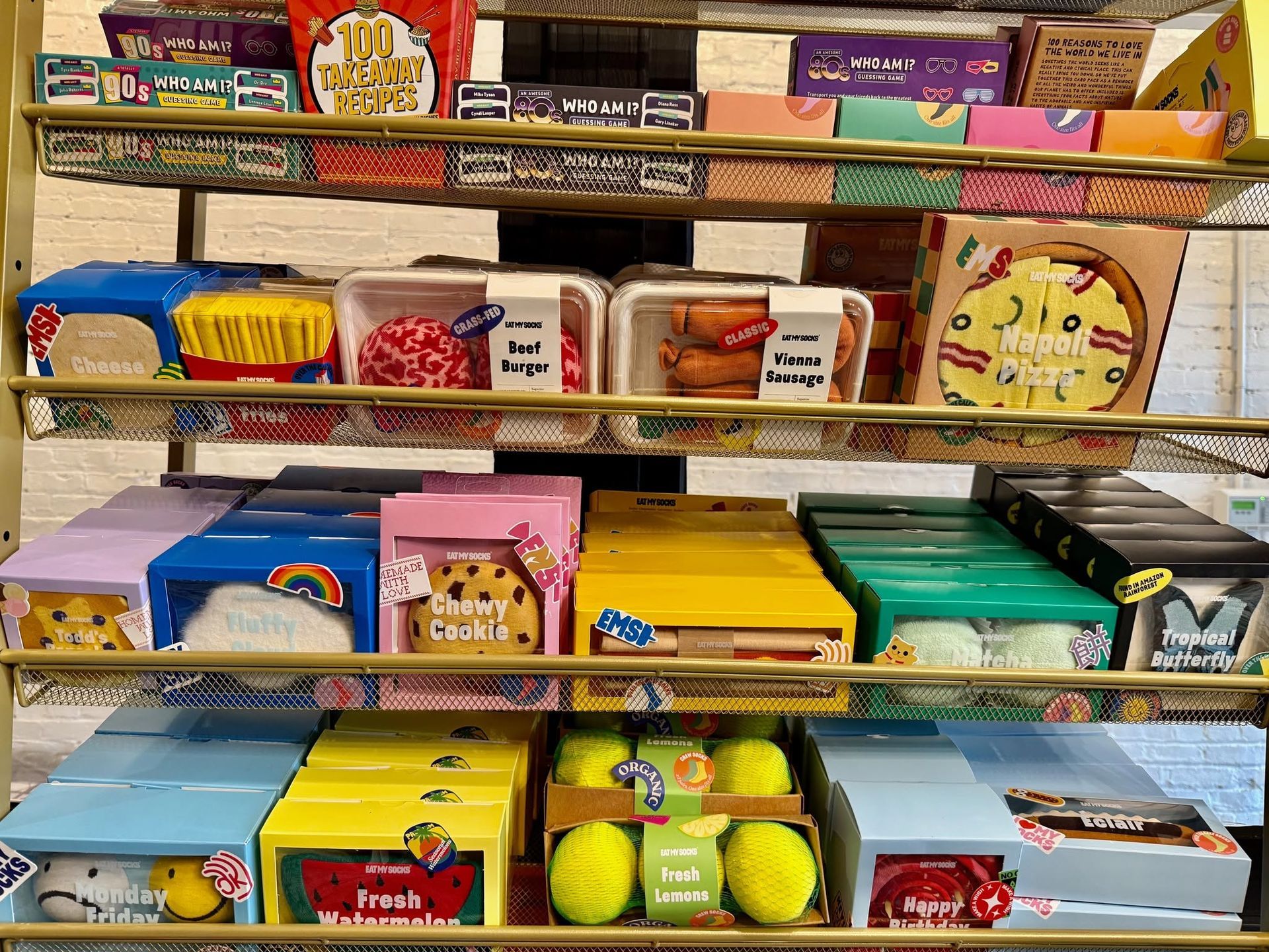 A shelf filled with boxes of candy and tennis balls.