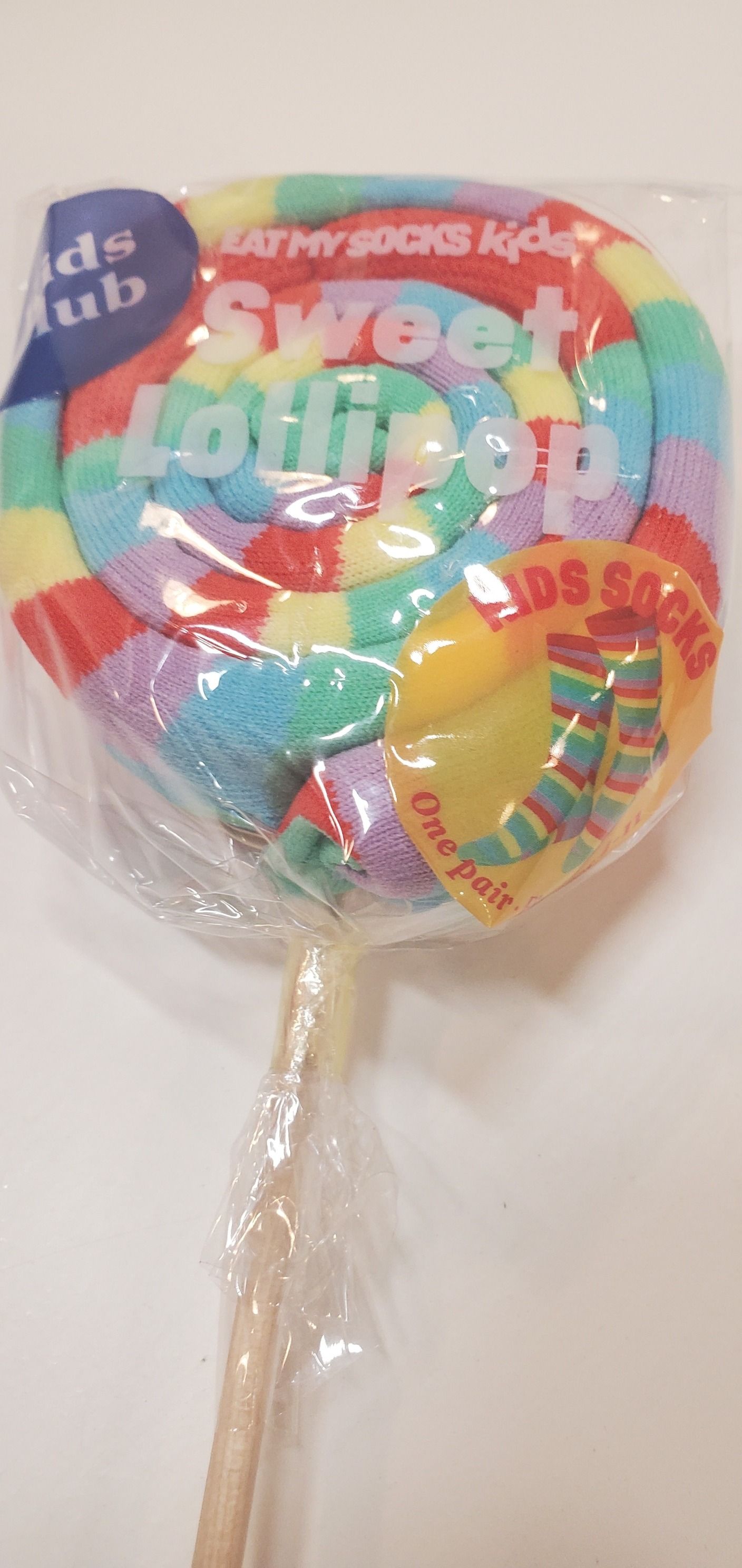 A rainbow colored sweet lollipop with a wooden stick