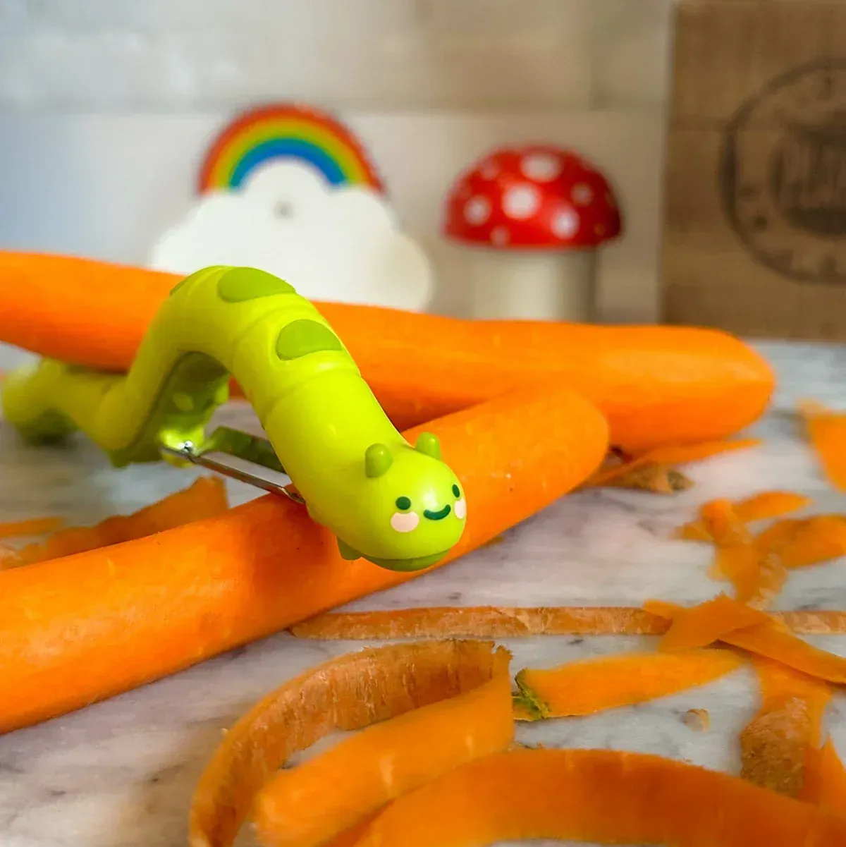 A green caterpillar is sitting on a pile of carrots