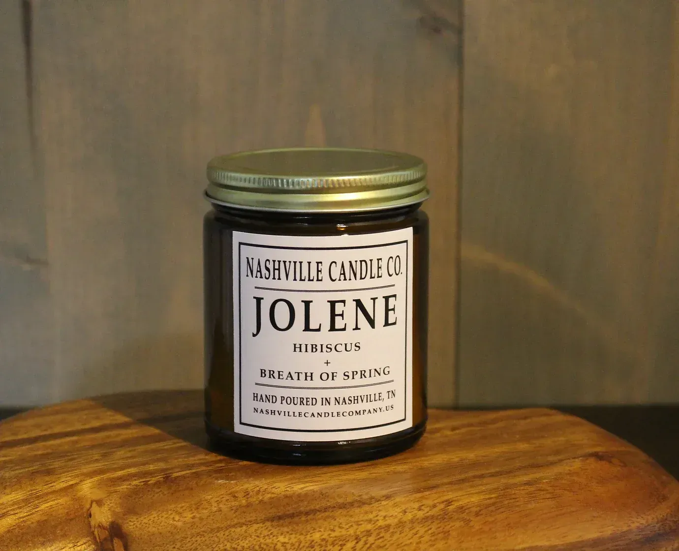 A jar of nashville candle co jolene sitting on a wooden table