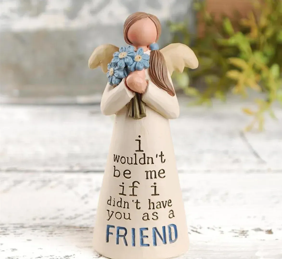 A figurine of an angel holding a bouquet of flowers