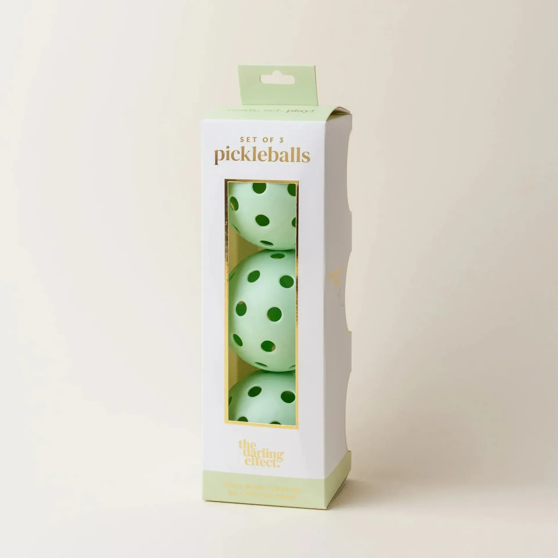 A box of pickleballs with green polka dots