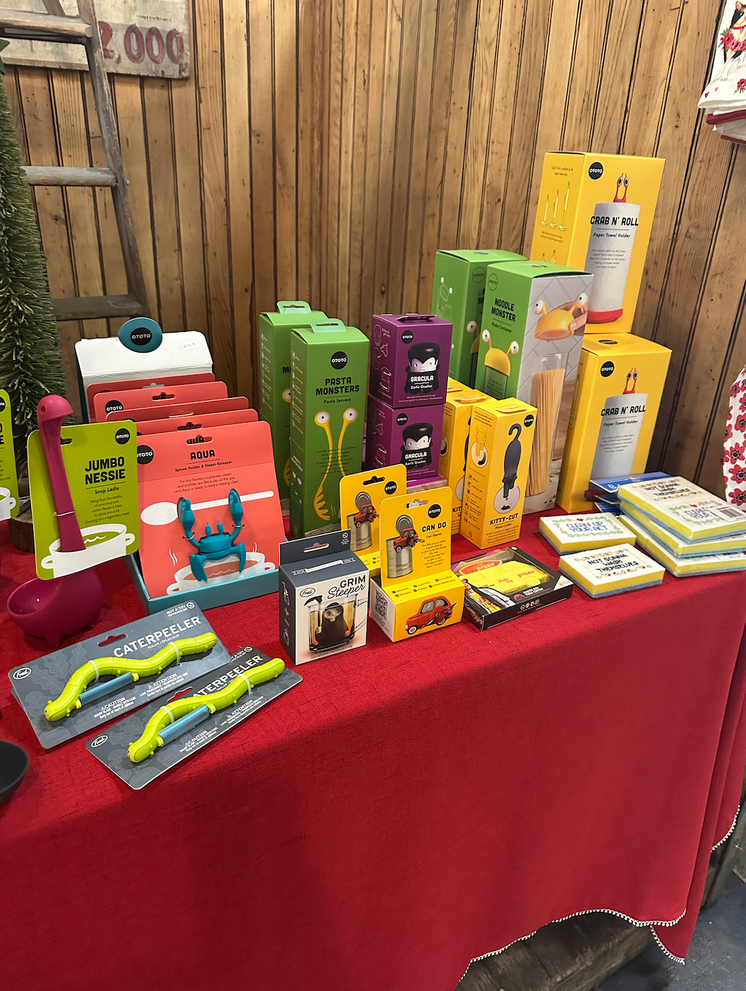 A table with a lot of boxes on it and a red table cloth.