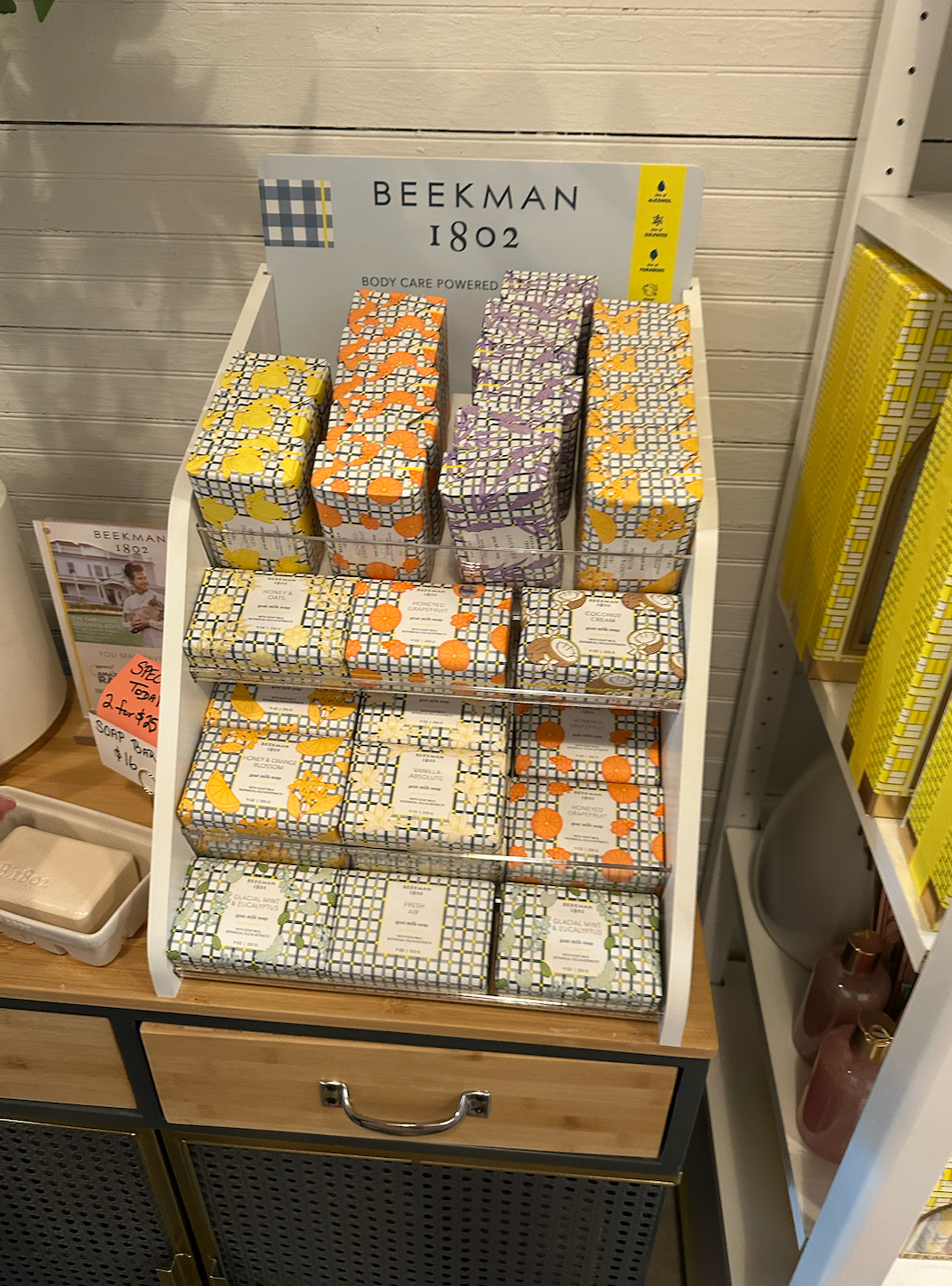 A display of soaps on a wooden table in a store.