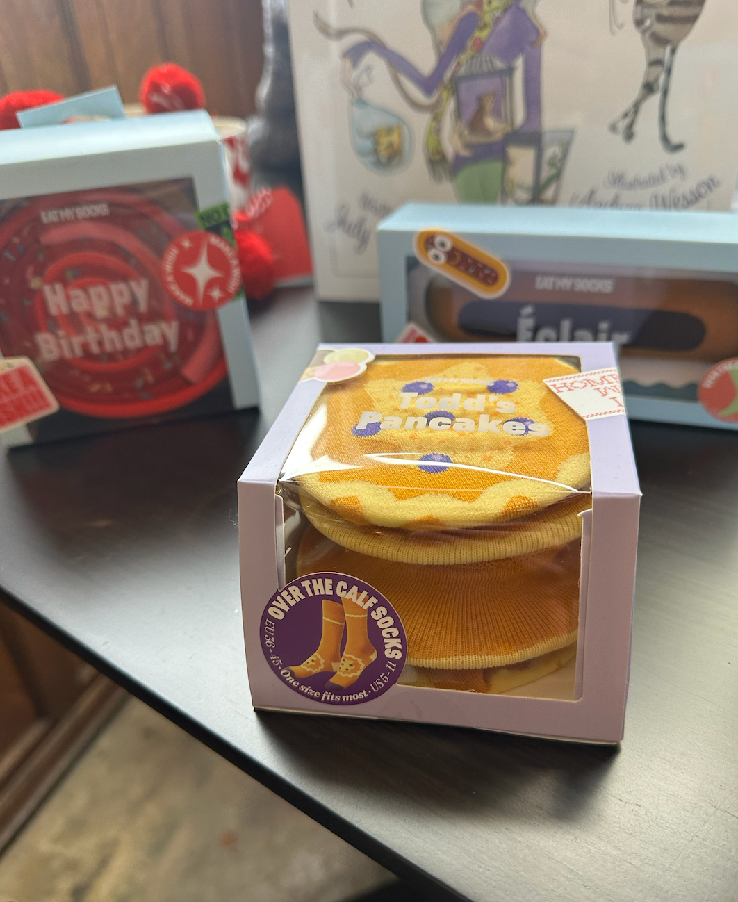 A box of pancakes sits on a table next to a happy birthday card