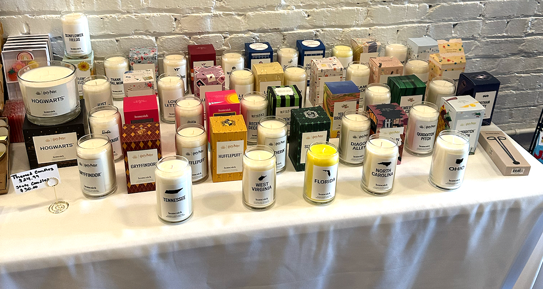 A table with dozens of unique candles at Treasure - The Gift Store 