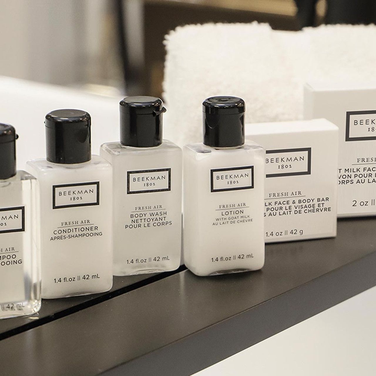 Several bottles of beckman lotion are lined up on a counter