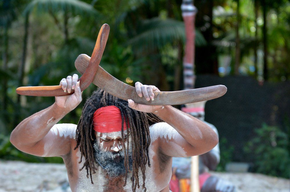 Man Holds Boomerangs During Aboriginal Culture Show — Tagalong Tours in Cairns, QLD