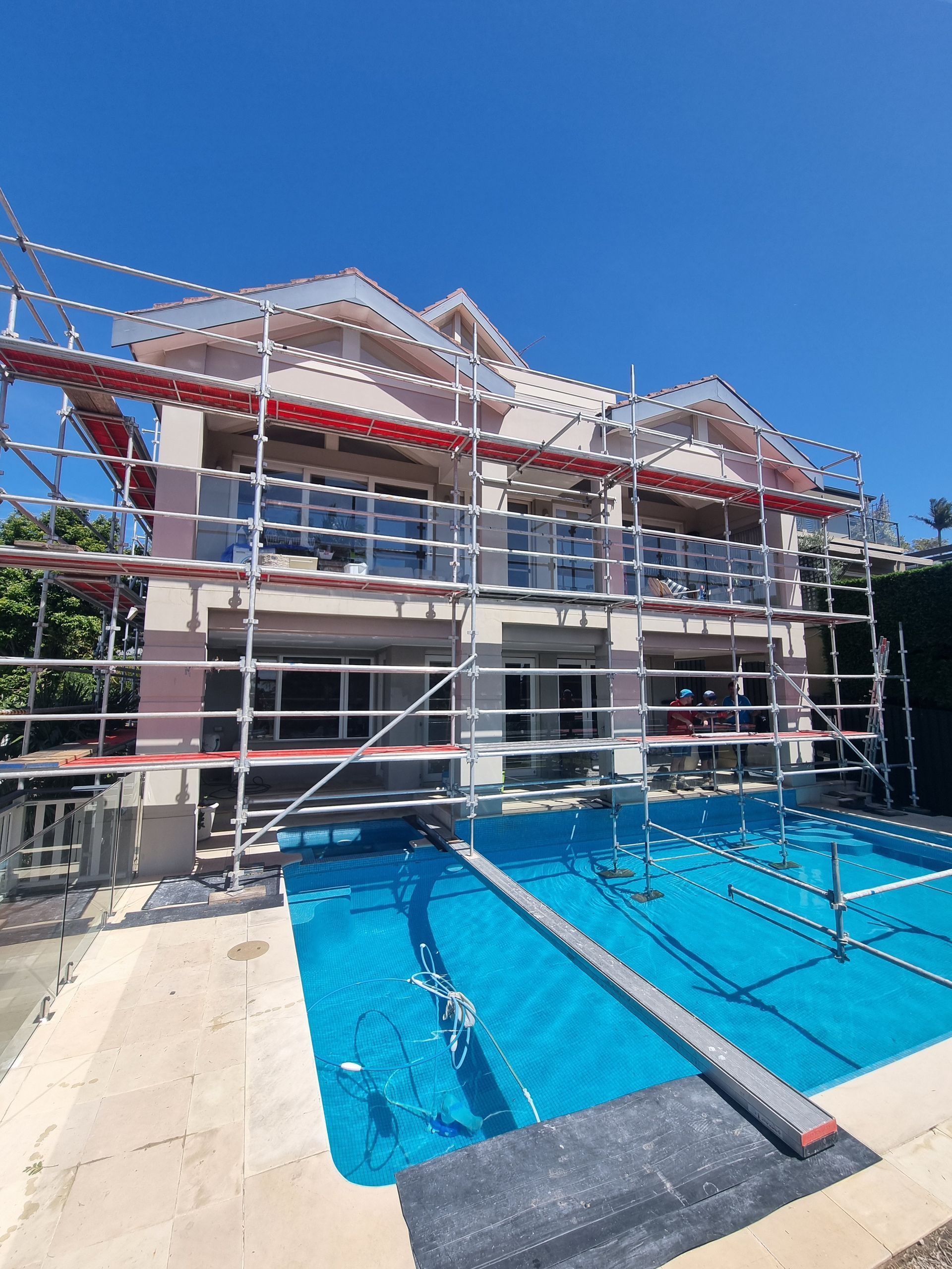 A scaffolding is sitting on the sidewalk next to a window.