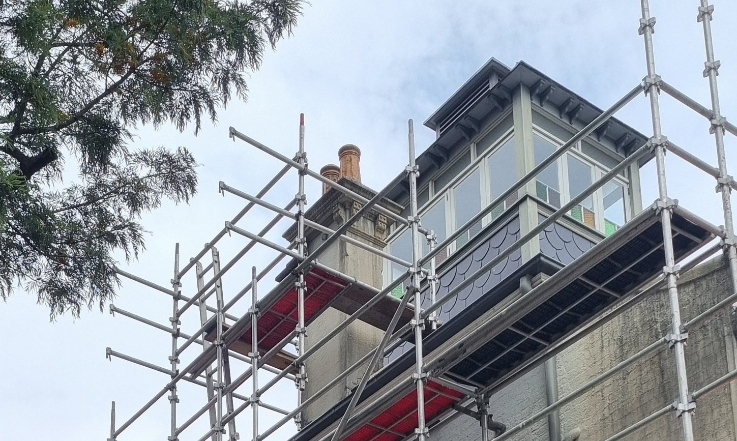 A large brick building with scaffolding around it is being built.