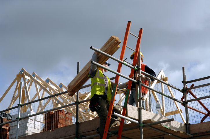 A large brick building with scaffolding around it is being built.