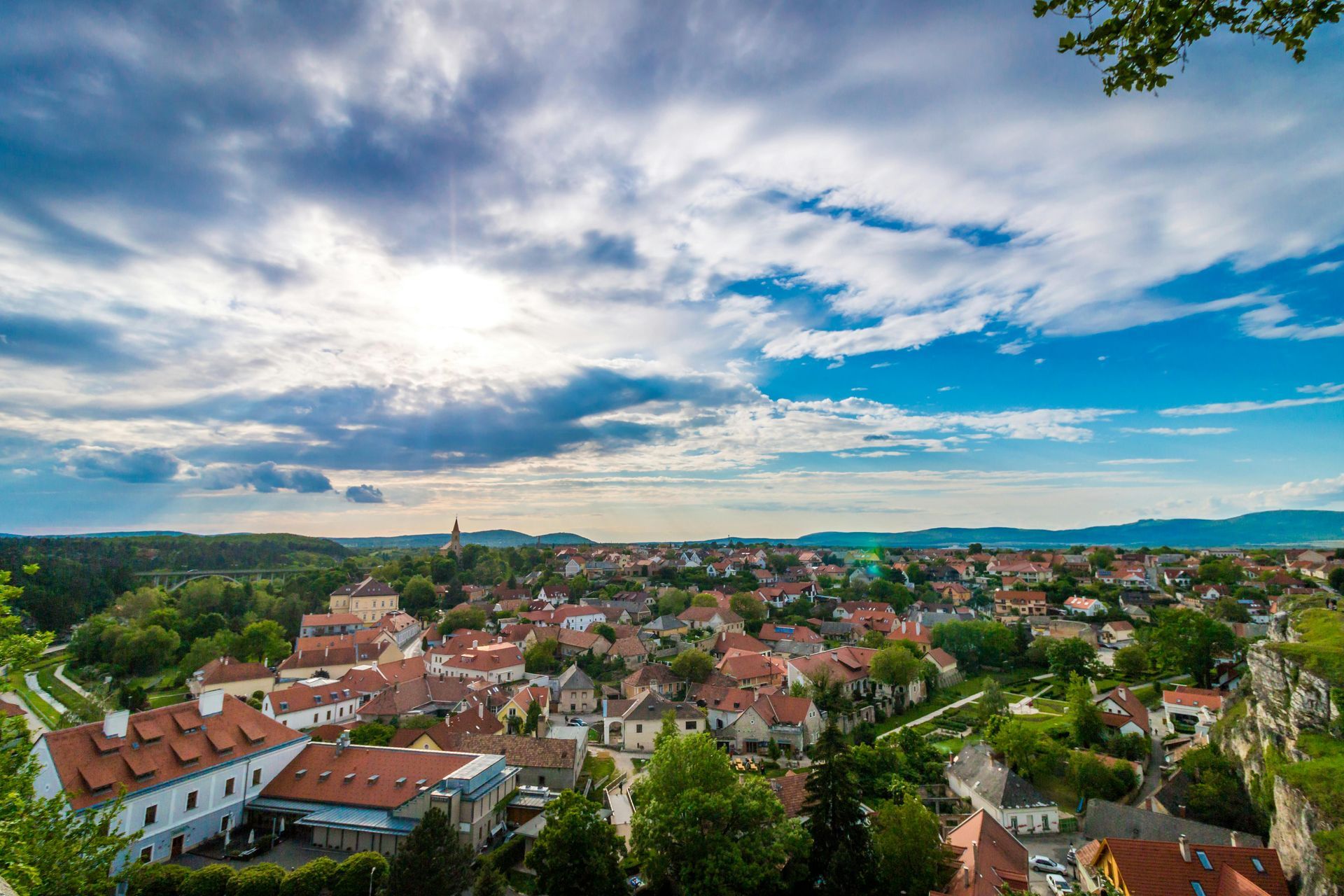 An aerial view of a small town with a blue sky and clouds in the background.