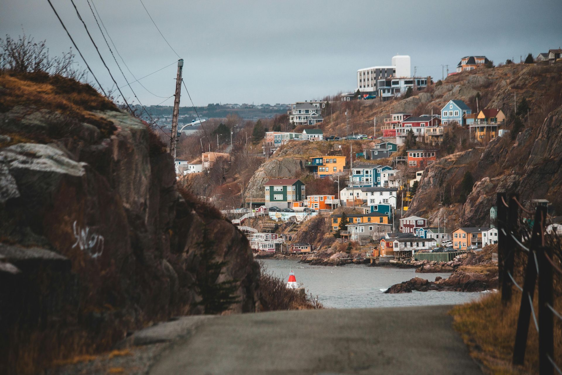 A road leading to a small town on the shore of a body of water.
