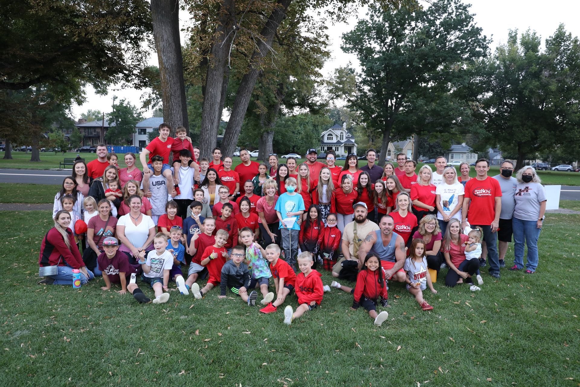 A large group of people are posing for a picture in a park.