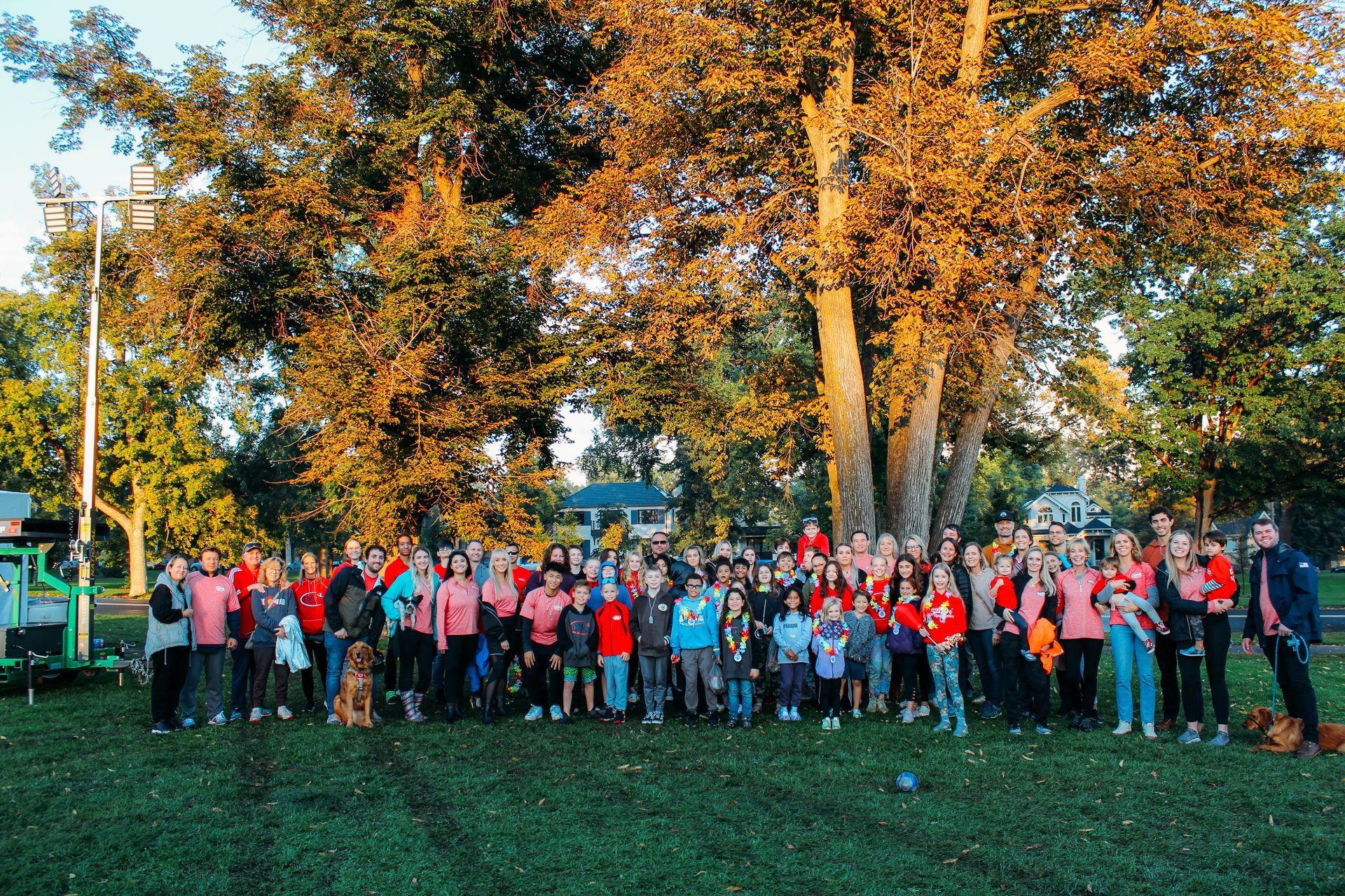 A large group of people are posing for a picture in a park.