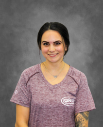 A woman wearing a purple shirt with a tattoo on her arm