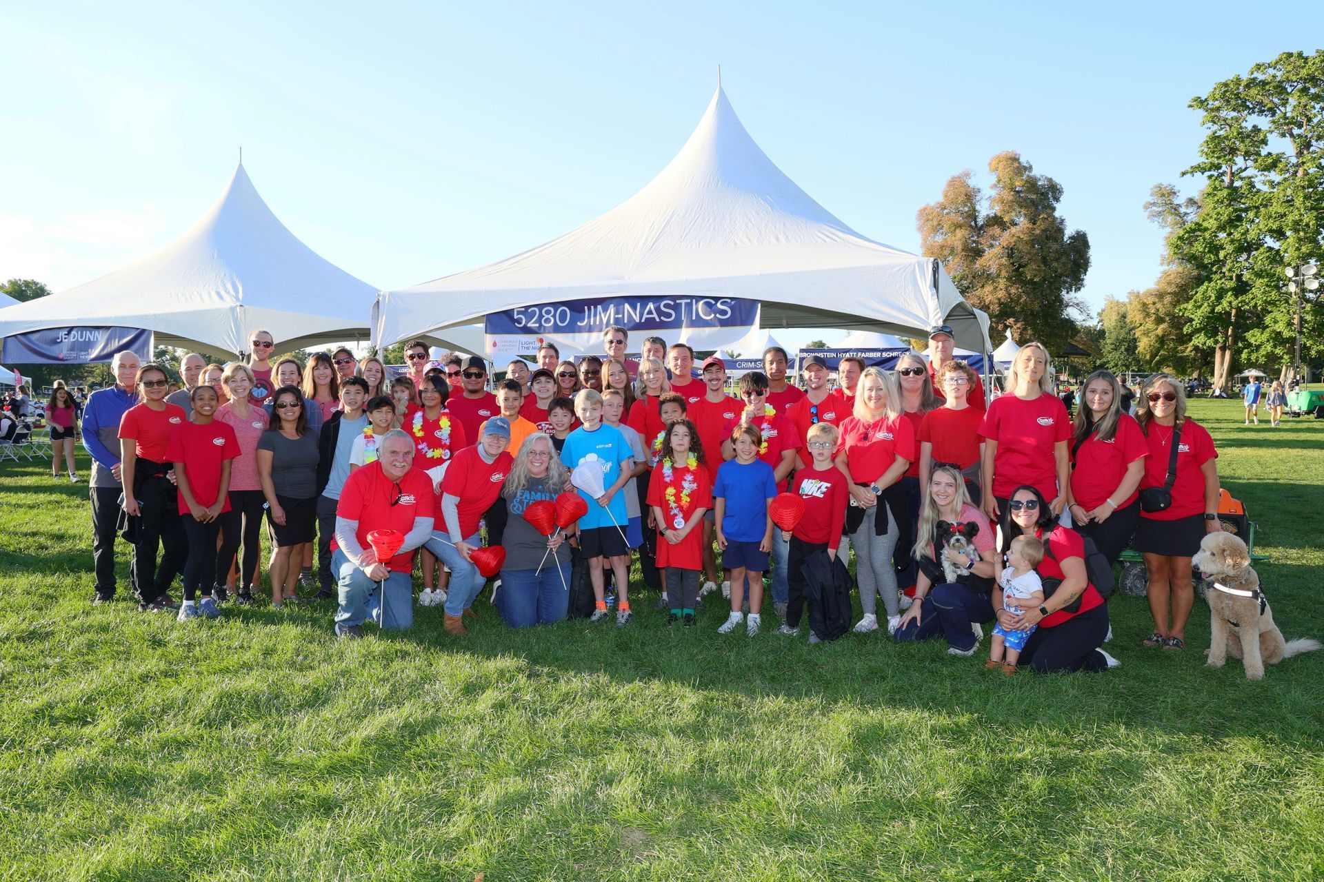 A large group of people are posing for a picture in a field.